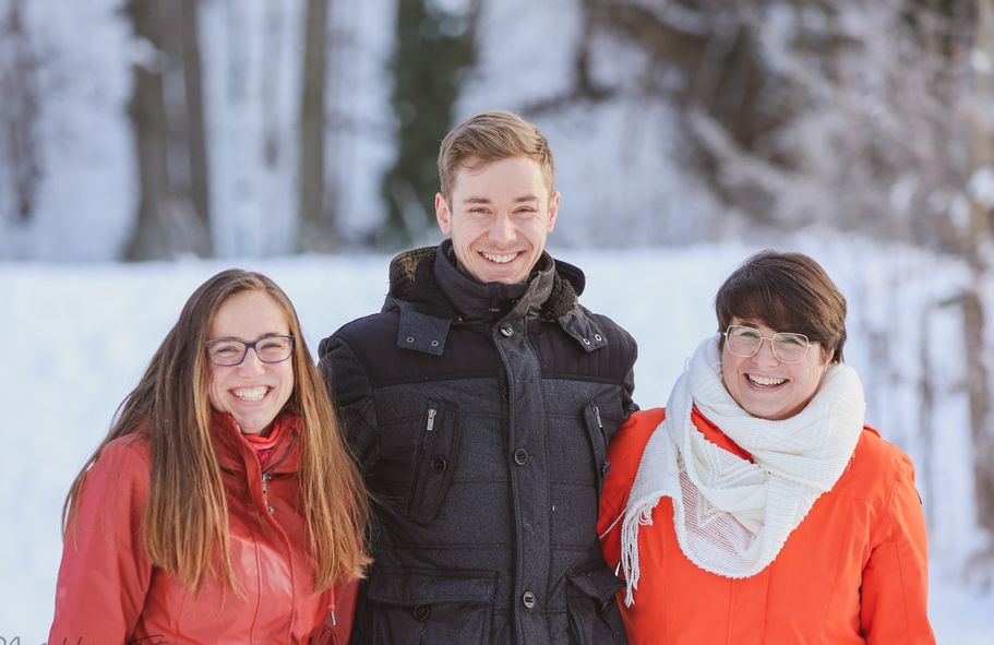 3 lächelnde Personen im Winter - Familienshooting