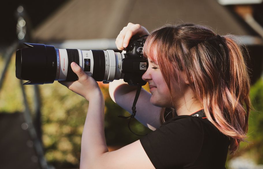 Person mit großem Objektiv bei einem Workshop